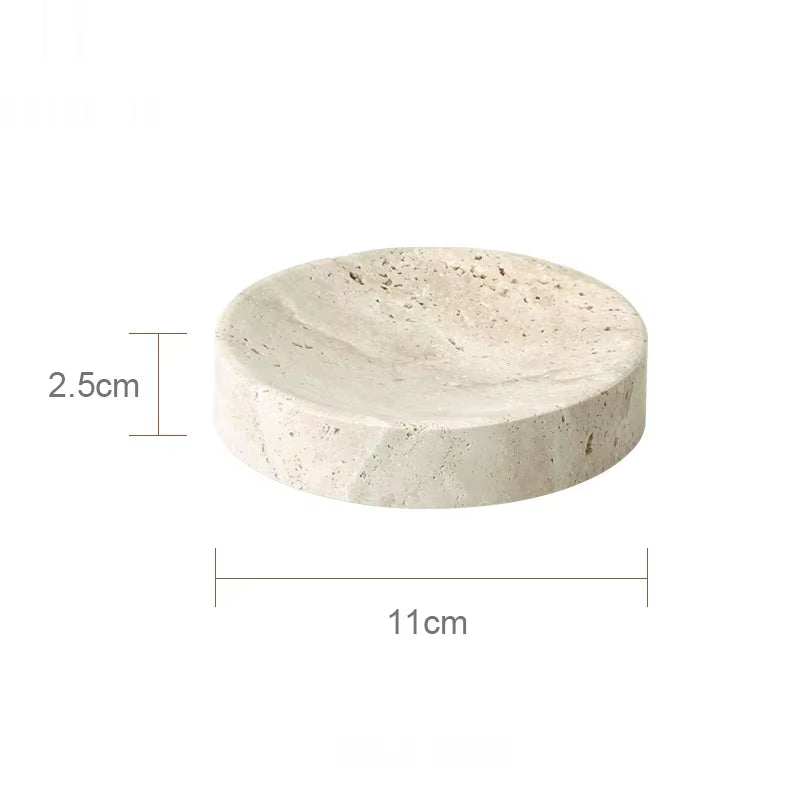 Travertine-look bathroom accessories set with soap dispenser, dish, and tray on a vanity.